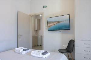 a bedroom with a bed and a tv on a wall at Rania's Seaside Nest- Steps from the Beach in Kiaton