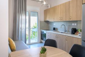 a kitchen with a table and a dining room with a balcony at Rania's Seaside Nest- Steps from the Beach in Kiaton