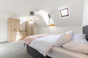 a bedroom with white walls and a bed with white pillows at Harbour View in Whitehaven