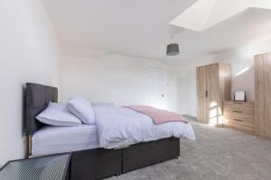 a bedroom with a large bed with white sheets at Harbour View in Whitehaven