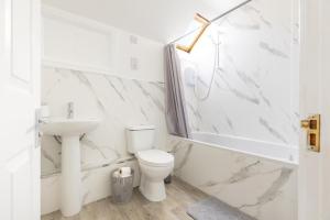 a white bathroom with a toilet and a sink at Harbour View in Whitehaven +8 photos