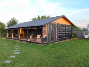 a house with a black roof on a yard at Cozy Box in Agapia