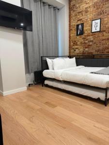 a bedroom with a bed and a brick wall at Chelsea Inn in New York