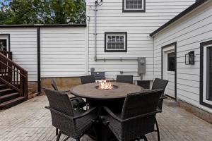 a patio with a table with chairs and a fire pit at Stylish KC FarmhouseHugeFencedYard in Merriam