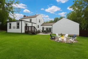 a yard with chairs and a fire pit in front of a house at Stylish KC FarmhouseHugeFencedYard in Merriam
