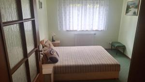 a bedroom with a bed and a window and a door at Domek nad jeziorem in Dorotowo