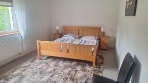 a bedroom with a wooden bed and a window at Domek nad jeziorem in Dorotowo