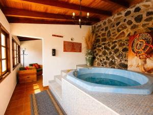 a large tub in a room with a stone wall at La Tanquera y Las Rosas in Los Realejos