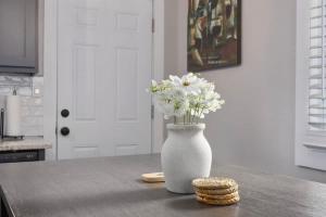 a white vase with white flowers on a table at Olathe corporate retreat in Olathe