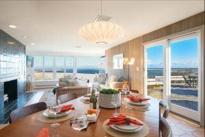 a dining room and living room with a table and chairs at Panoramic Water Views w Private Beach in Chatham +36 photos
