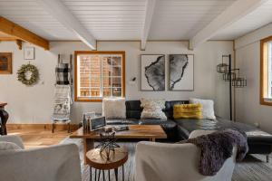 a living room with a black couch and a table at Aery Pines in Wrightwood +74 photos