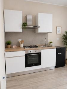 a kitchen with white cabinets and a stove top oven at La Casa nella Contea in Terni