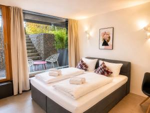 a bed with two pillows on it in a room at Lake Vibe Studio Apartment Wangen in Öhningen