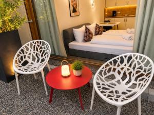 two chairs and a table in a room with a bed at Lake Vibe Studio Apartment Wangen in Öhningen