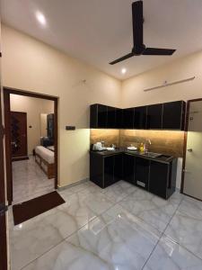 a room with a kitchen with a ceiling fan at Uni Stay Inn in Cochin