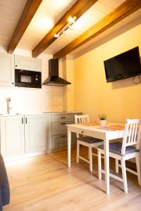 a kitchen with a table and chairs in a room at Apartamentos San Roque in Arenas de Cabrales