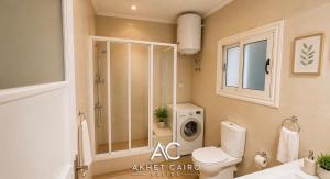a bathroom with a toilet and a washing machine at Akhet Cairo Suites in Cairo