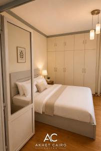 a bedroom with a large bed and a mirror at Akhet Cairo Suites in Cairo +7 photos