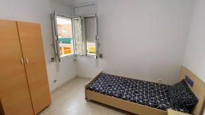 a small bedroom with a bed and a window at Casa Cómoda in Nabeul