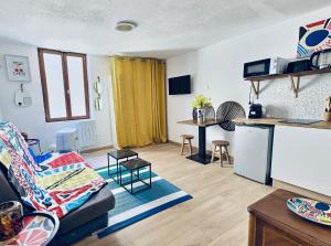 a living room with a couch and a kitchen at Summer vibes Béziers centre in Béziers