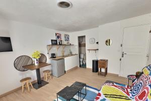 a living room with a table and a kitchen at Summer vibes Béziers centre in Béziers