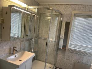 a bathroom with a shower and a sink and a mirror at Best place to live in Trondheim