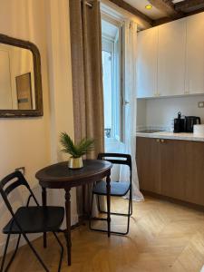 a table and chairs in a room with a kitchen at Studio cosy avec parking près de Paris Expo Porte de Versailles in Vanves