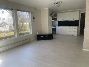 an empty room with a kitchen and a large window at Best place to live in Trondheim