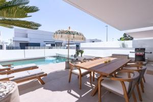 a patio with a table and chairs and a pool at Luxe zuiderse villa in Dolores