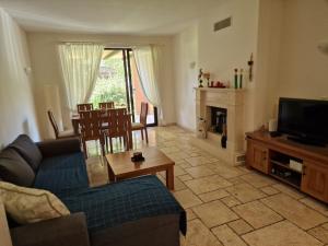 a living room with a couch and a tv and a table at Kaliakria Garden in Topola