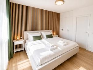 a bedroom with a large white bed with two towels at Apartmán Javorná Living in Čachrov