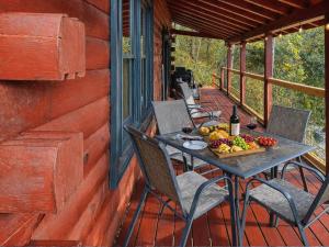 a table with a bowl of fruit on a porch at UnBearably Cozy - pool table, fire pit, central location in Bryson City