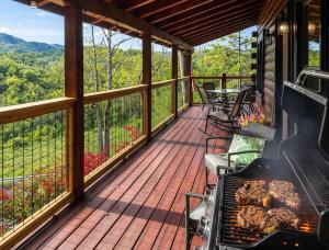 a screened in porch with a grill and tables and chairs at UnBearably Cozy - pool table, fire pit, central location in Bryson City