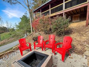 four red chairs sitting next to a fire pit at UnBearably Cozy - pool table, fire pit, central location in Bryson City