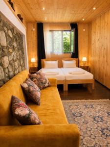 a hotel room with two beds and a couch at Guest House Keti Margiani Mestia in Mestia +130 photos