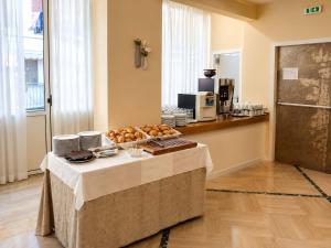 a table with a plate of food on top of it at Hotel La Fenice in Lido di Jesolo +13 photos