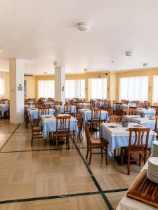 a dining room with blue tables and wooden chairs at Hotel La Fenice in Lido di Jesolo