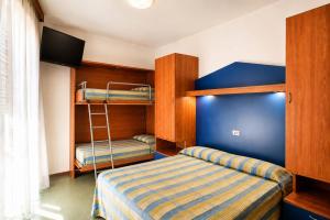 a bedroom with bunk beds and a bed with a ladder at Hotel La Fenice in Lido di Jesolo