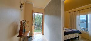 a bedroom with a bed and a large window at Pousada Canto Bonito centro de Rolante in Rolante