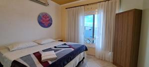 a bedroom with a bed and a large window at Pousada Canto Bonito centro de Rolante in Rolante