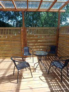 a patio with four chairs and a table on a deck at Miła Przystań in Debrzno