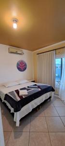 a bedroom with a bed in a room with a window at Pousada Canto Bonito centro de Rolante in Rolante