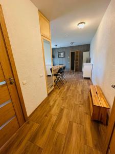 a room with a wooden floor and a table at Rožu namu apartamenti 6 in Kuldīga