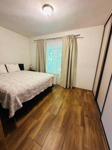 a bedroom with a bed and a wooden floor at Rožu namu apartamenti 6 in Kuldīga