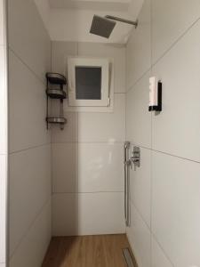 a white bathroom with a shower with a window at DOWNTOWN 4 in Alexandroupoli