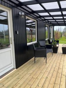 a screened in porch with chairs and windows at Varde Bed and Kitchen Annekset in Varde