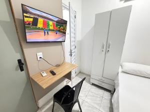 a room with a tv and a chair and a bed at Mini Ap no derby com Garagem in Sobral