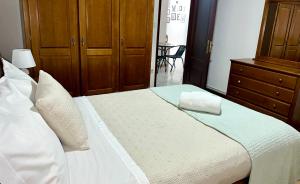 a bedroom with a large white bed with wooden cabinets at Sweet Home in Miranda do Douro