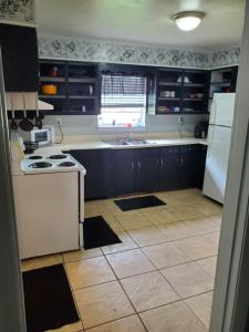 a kitchen with blue cabinets and a white refrigerator at Comfortable home in Mobile