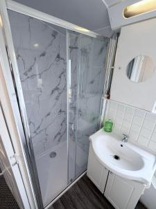 a bathroom with a shower and a sink at Fantasy Lodge Sunnymede in Ingoldmells +7 photos